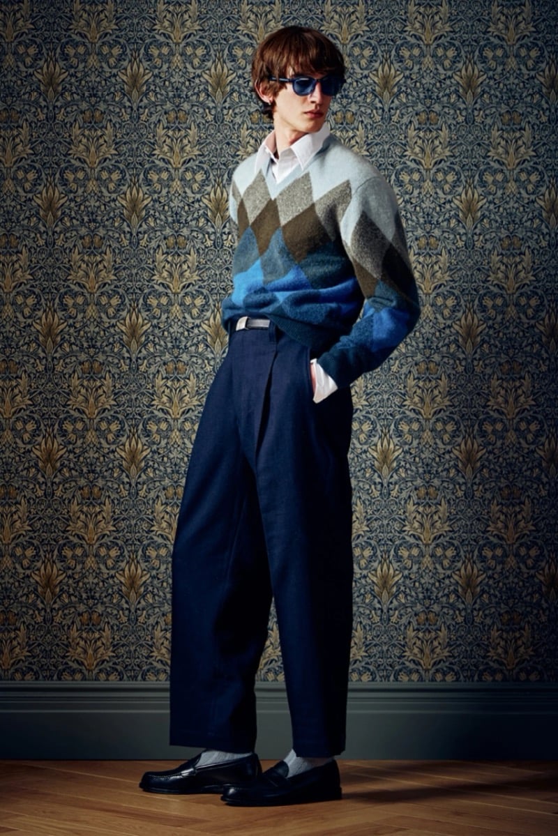 Man in a blue and gray argyle sweater and dark trousers, wearing sunglasses, for Todd Snyder Fall 2026