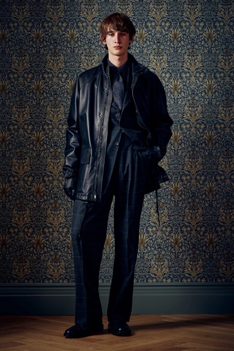 Man in a dark leather jacket over a suit, wearing gloves, for Todd Snyder Fall 2026