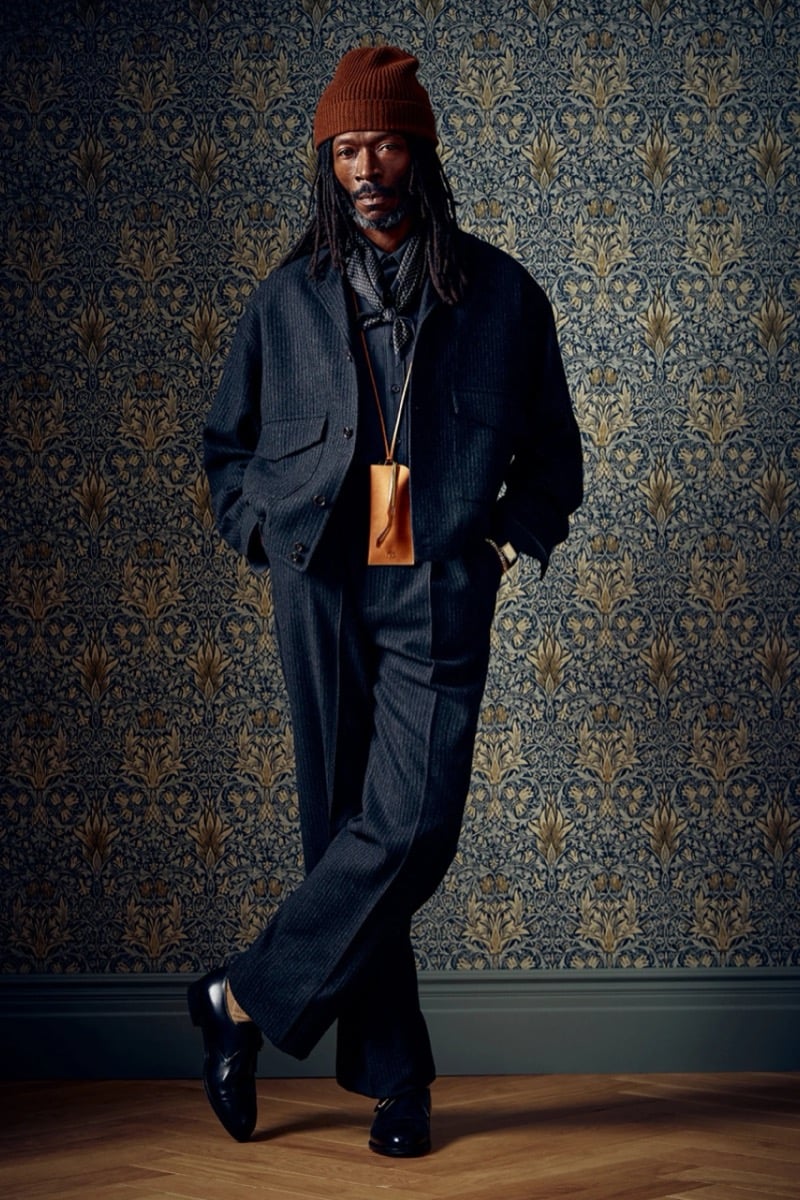Man in a dark pinstripe jacket and trousers with an orange beanie, for Todd Snyder Fall 2026