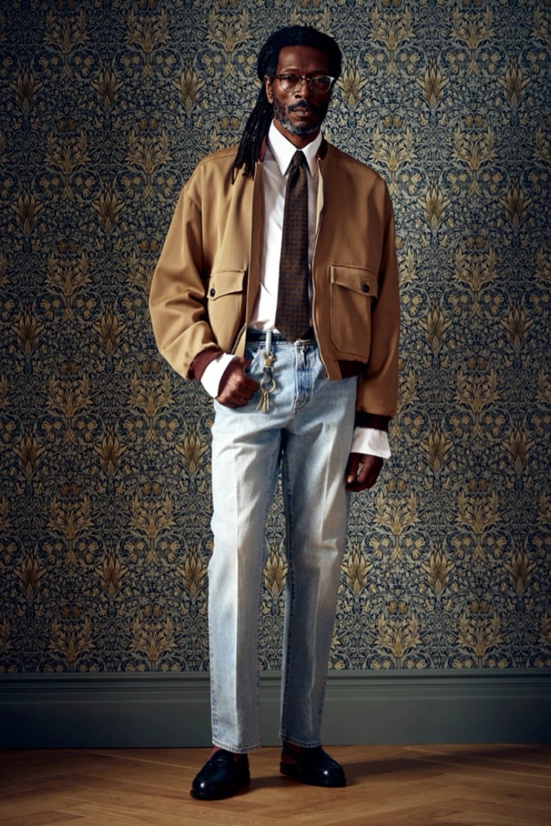Man in a tan trucker jacket and tie over light jeans, for Todd Snyder Fall 2026
