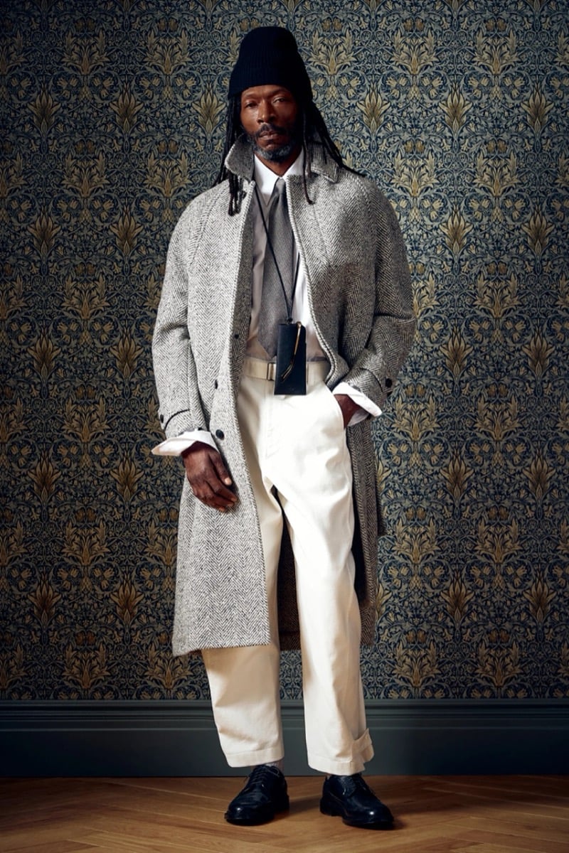Man in a gray herringbone coat with a tie and light-colored trousers, for Todd Snyder Fall 2026