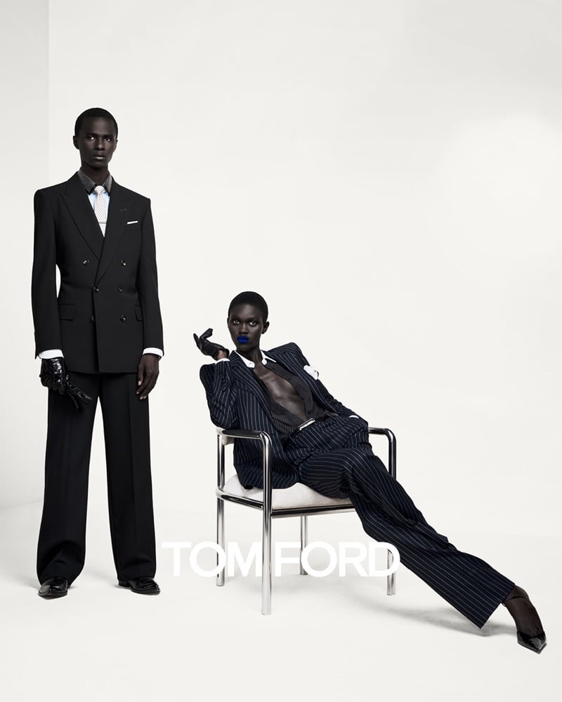 Malick Bodian in a double-breasted suit and leather gloves stands beside Aluel Makuach, who reclines in an open pinstripe suit with a cobalt lip, for Tom Ford's fall-winter 2026 campaign