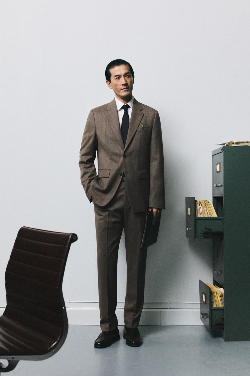 Daisuke Ueda wears a brown suit with a navy tie and holds a leather portfolio beside an office filing cabinet for Zara's back to work 2026 campaign