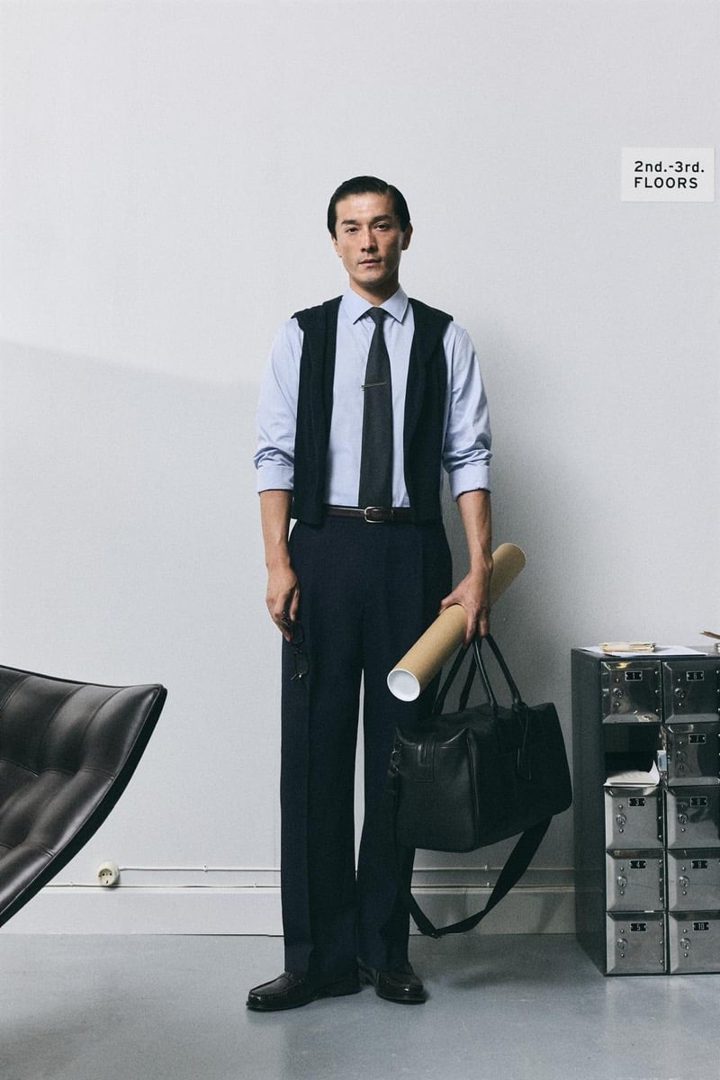 Daisuke Ueda wears a light blue shirt and dark tie with navy trousers, a black duffel bag in hand, for Zara's back to work 2026 campaign