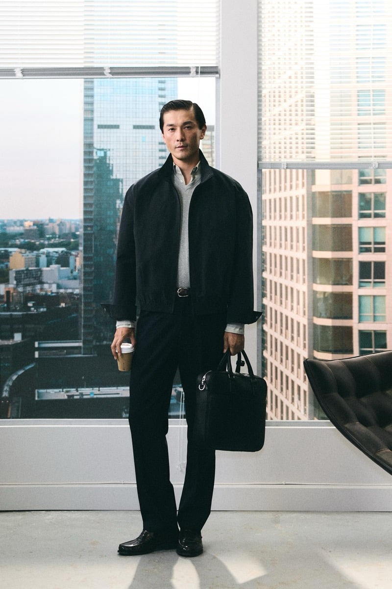 Daisuke Ueda wears a black jacket over a gray sweater and holds a coffee cup and briefcase for Zara's back to work 2026 campaign