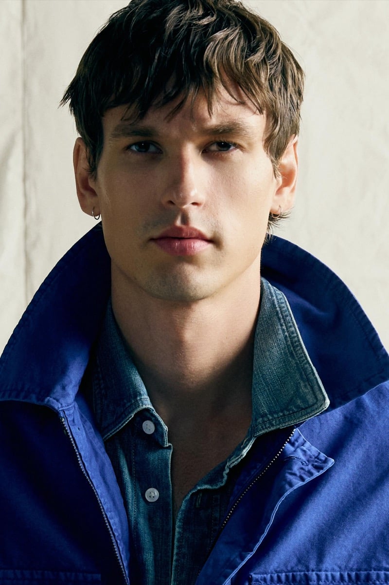 Jegor Venned in a cobalt utility jacket over a denim shirt, close-up portrait
