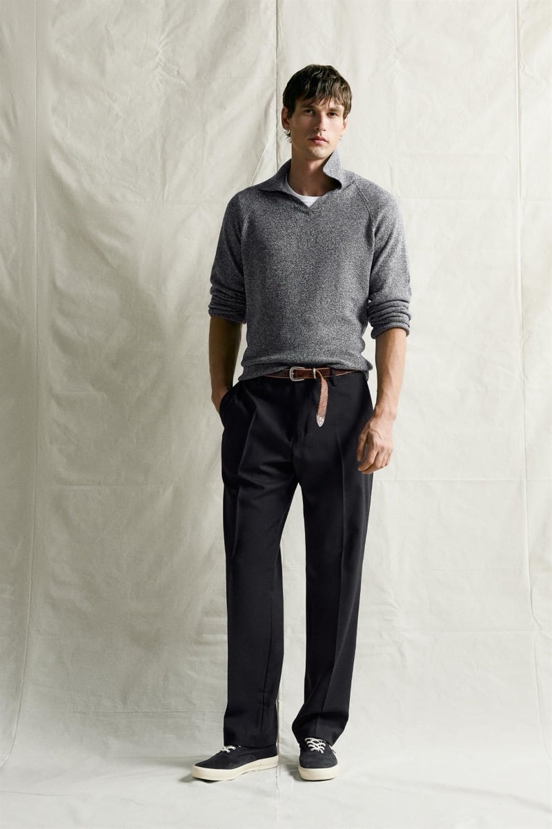 Jegor Venned in a gray knit polo with a popped collar and narrow leather belt