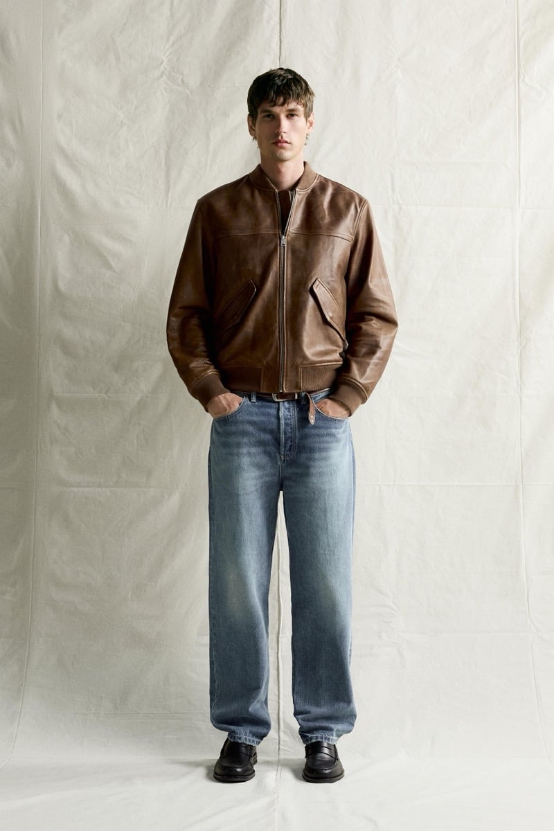 Jegor Venned in a brown leather bomber jacket with faded jeans and loafers