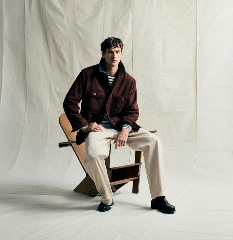 Jegor Venned seated in a brown multi-pocket jacket over a striped shirt with roomy trousers