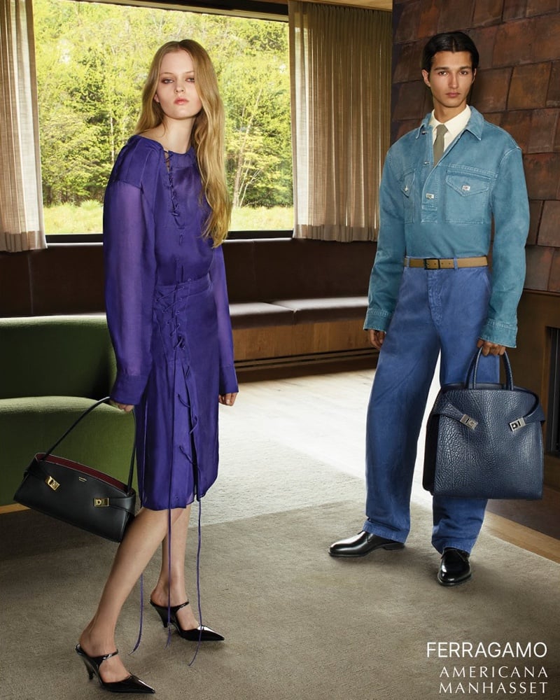 Ava Shipp in a purple lace-up midi dress with black slingback heels and Ruben Bilan-Carroll in a faded blue denim jacket, tie, and blue jeans holding a black leather tote, photographed in a midcentury wood-paneled living room for Ferragamo