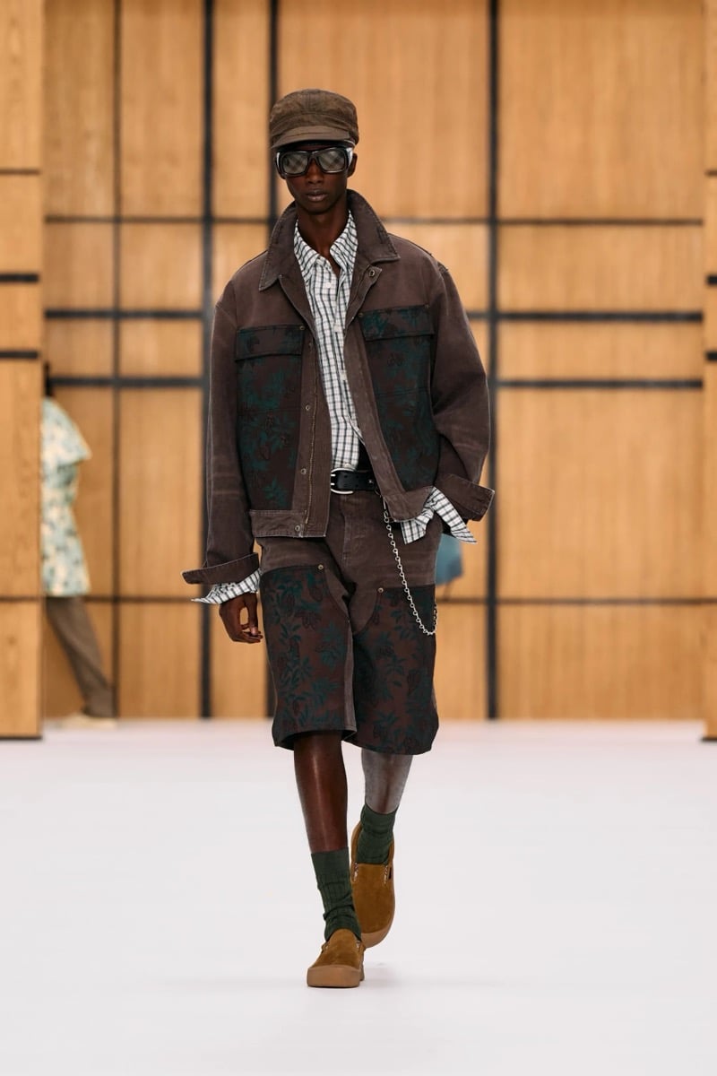 A model in a cap and brown denim jacket with matching shorts, layered over a check shirt, for Burberry's summer 2027 collection