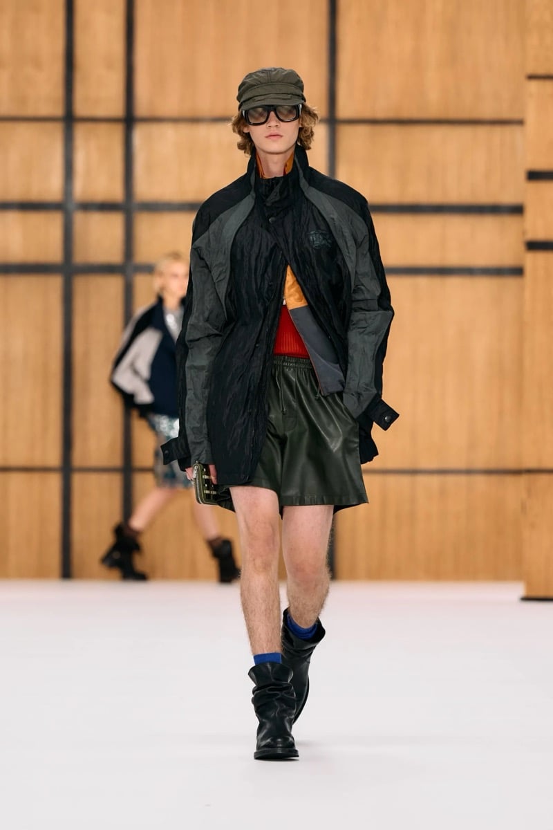 A model in a cap and paneled jacket, with leather shorts and slouchy boots, for Burberry's summer 2027 collection
