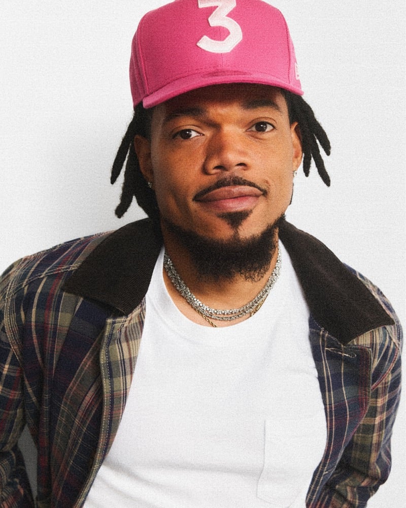 Chance the Rapper in a pink 3 cap, plaid J.Crew Barn Jacket with a corduroy collar, and layered chains