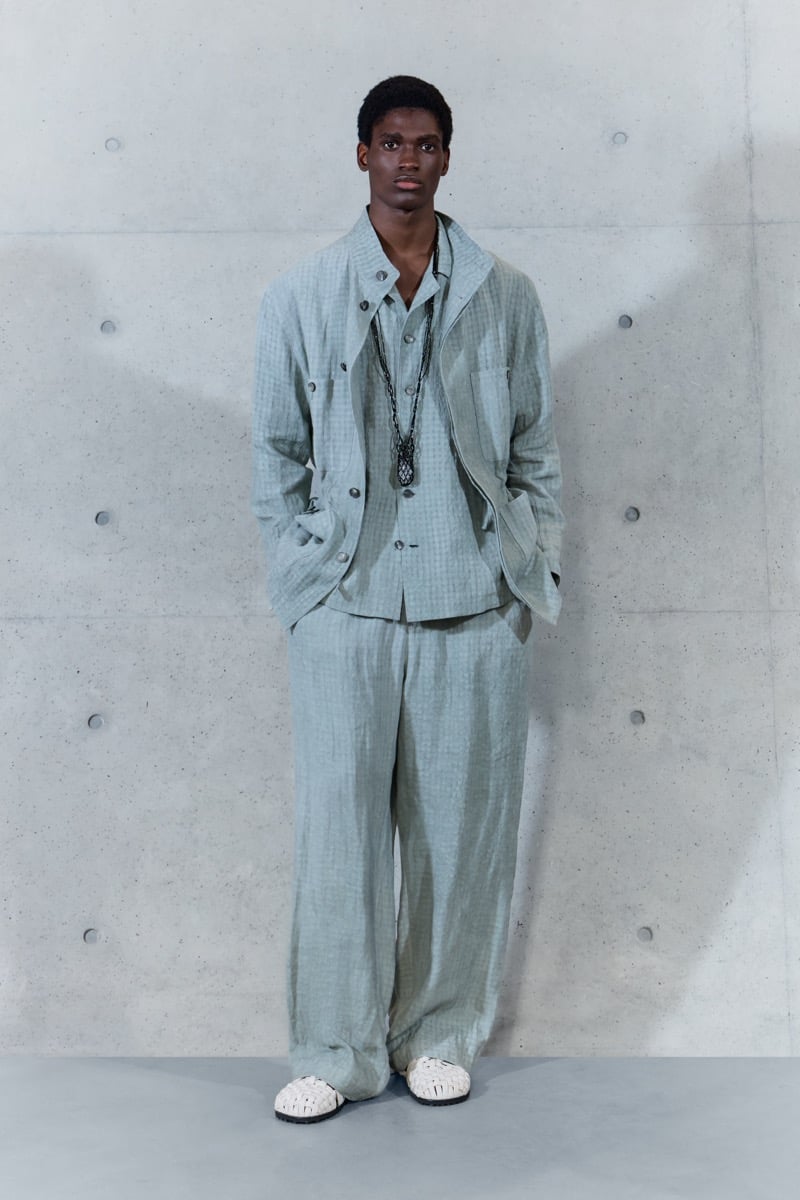 A model in a check linen jacket over a matching shirt and trousers, with a pendant necklace, for Emporio Armani's spring-summer 2027 collection