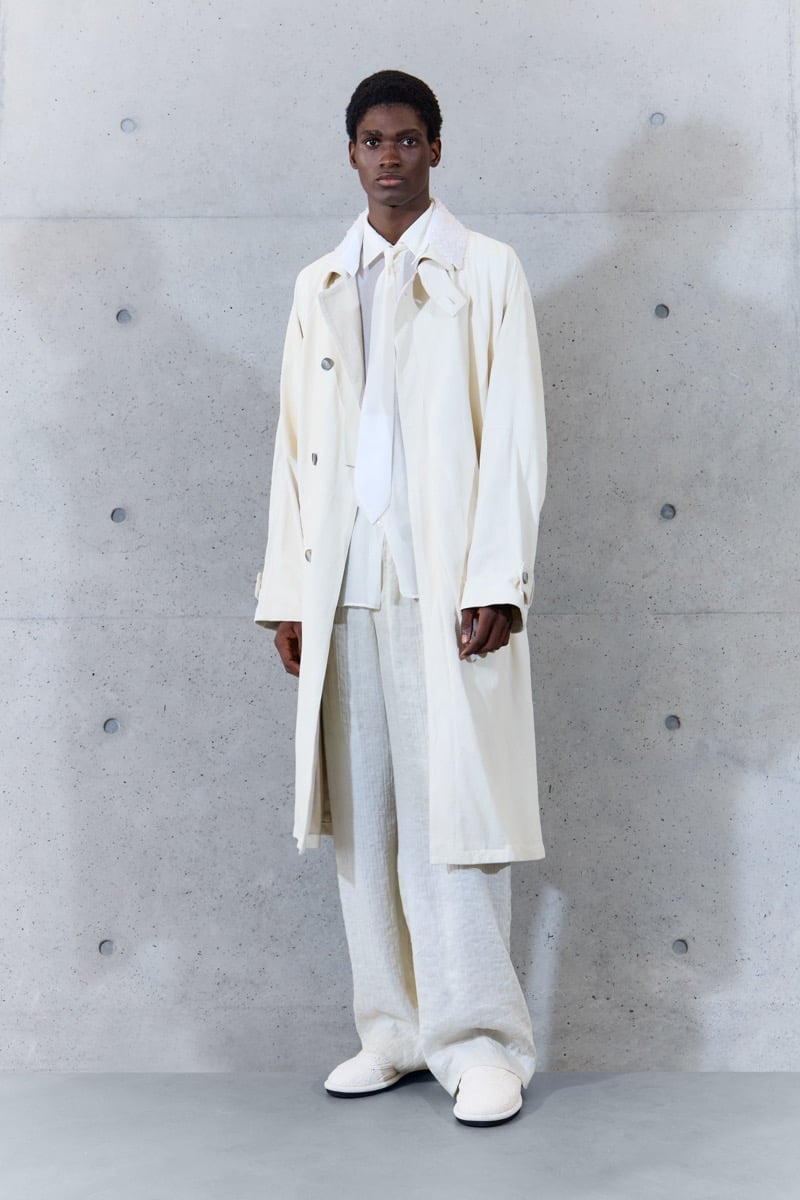 A model in a double-breasted coat over a shirt and narrow scarf, with linen wide-leg trousers, for Emporio Armani's spring-summer 2027 collection