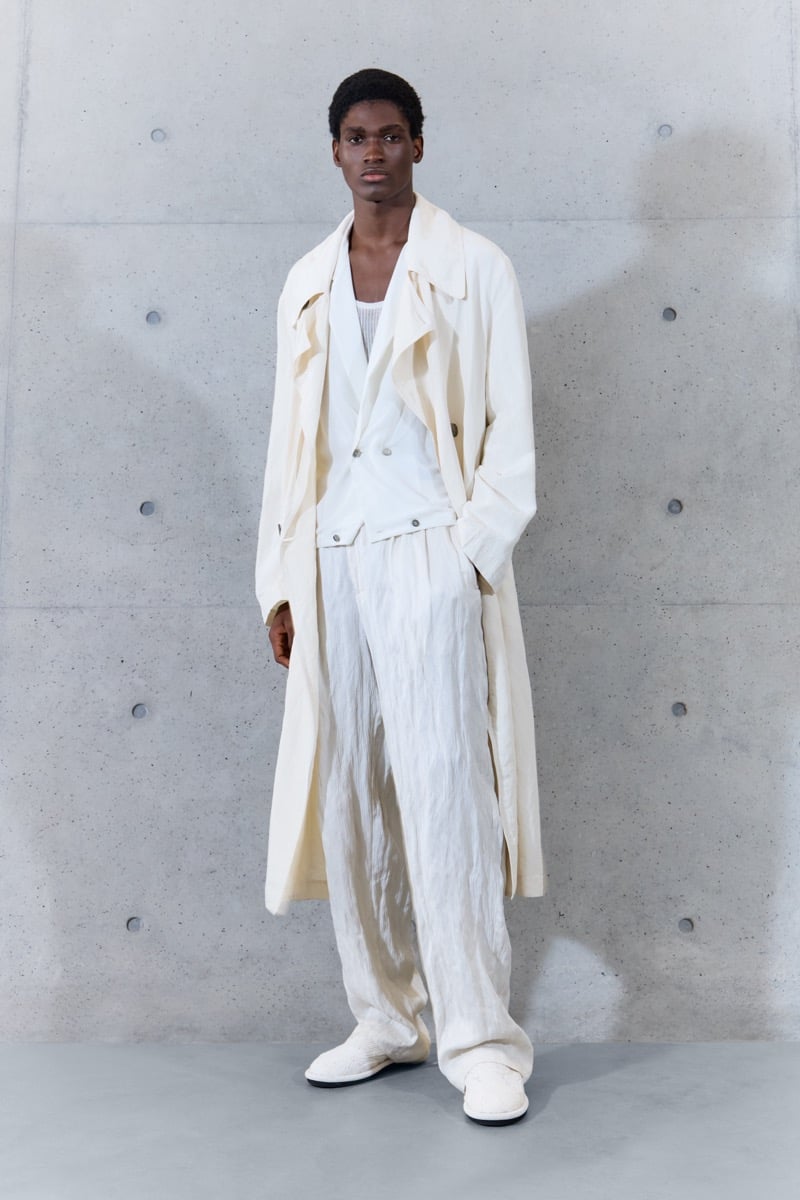 A model in a long trench coat over a waistcoat and tank, with crinkled wide-leg trousers, for Emporio Armani's spring-summer 2027 collection