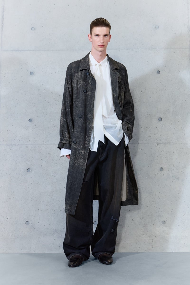 A model in a mottled coat over a sheer shirt and narrow scarf, with wide-leg trousers, for Emporio Armani's spring-summer 2027 collection