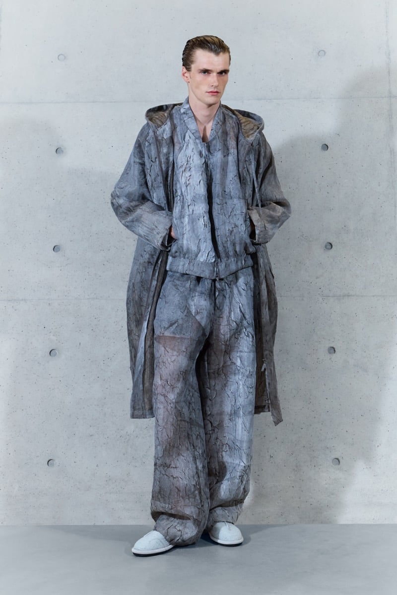 A model in a sheer crackle-print hooded parka over a matching jacket and sheer trousers, for Emporio Armani's spring-summer 2027 collection
