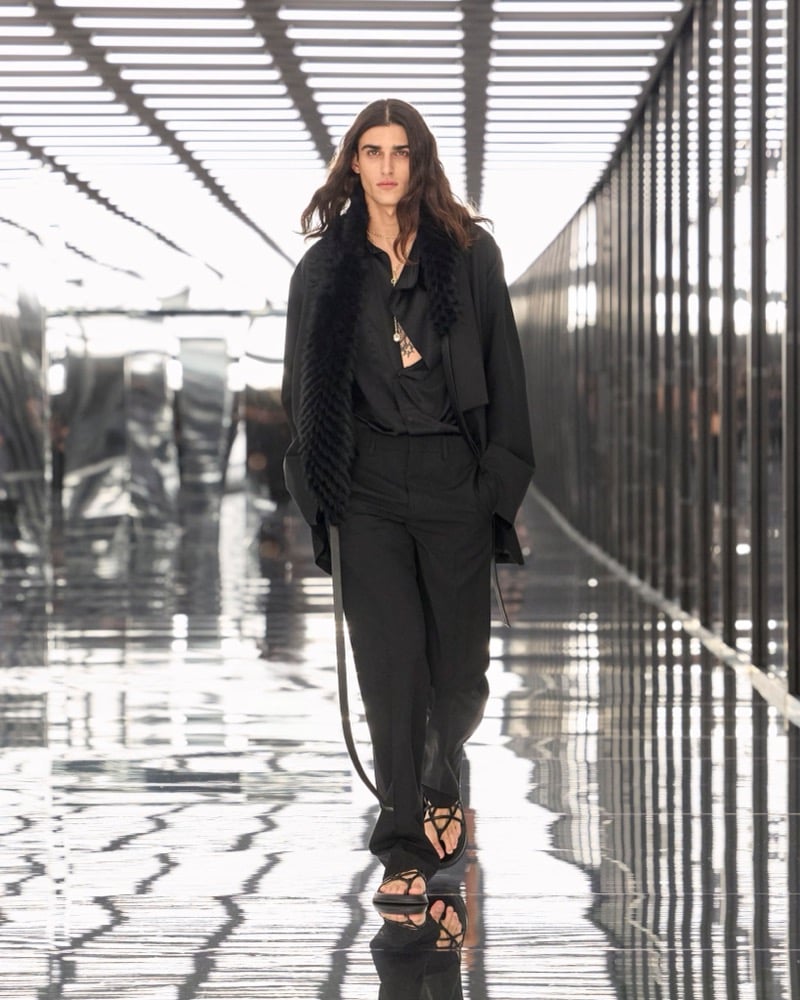 A model in a fur stole over a draped jacket and open shirt, with trousers and strappy sandals, for Fendi's spring-summer 2027 collection