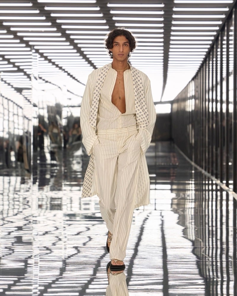A model in a pinstripe coat with printed facings over a plunging shirt and matching trousers, for Fendi's spring-summer 2027 collection