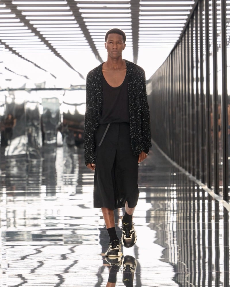 A model in a speckled knit cardigan over a scoop-neck tank, with long shorts and sneakers, for Fendi's spring-summer 2027 collection