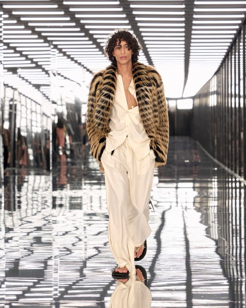 A model in a striped fur jacket over a plunging shirt, with fluid wide-leg trousers, for Fendi's spring-summer 2027 collection