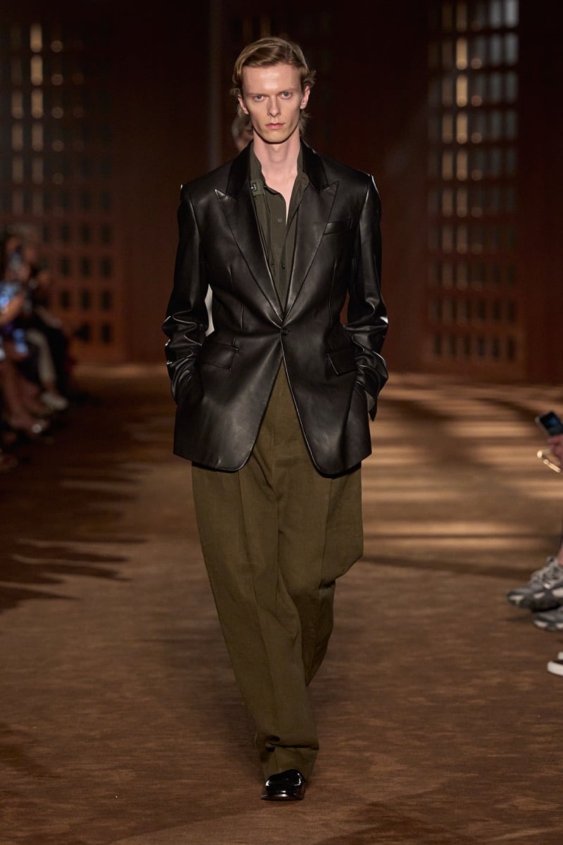 A model in a peak-lapel leather blazer over a shirt, with olive pleated trousers, for Ferragamo's spring-summer 2027 collection