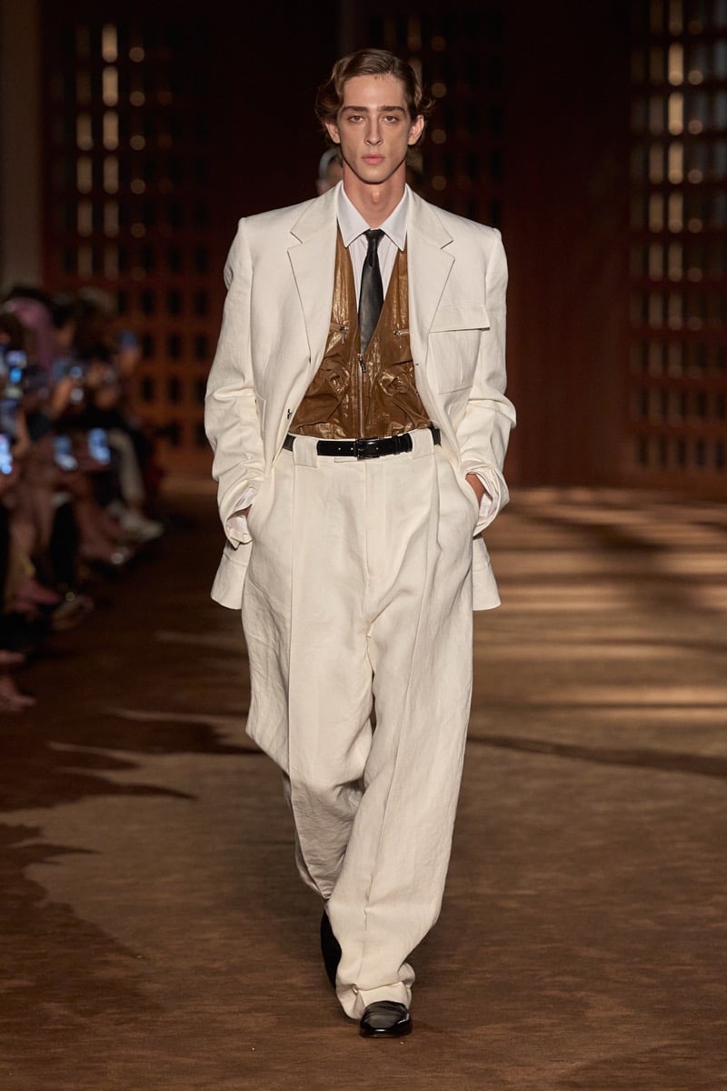 A model in a linen suit over a glossy zip-front vest, shirt, and tie, for Ferragamo's spring-summer 2027 collection