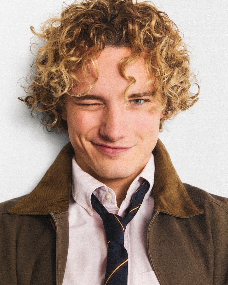 Graham Campbell winks in a J.Crew Barn Jacket with a corduroy collar, oxford shirt, and striped tie