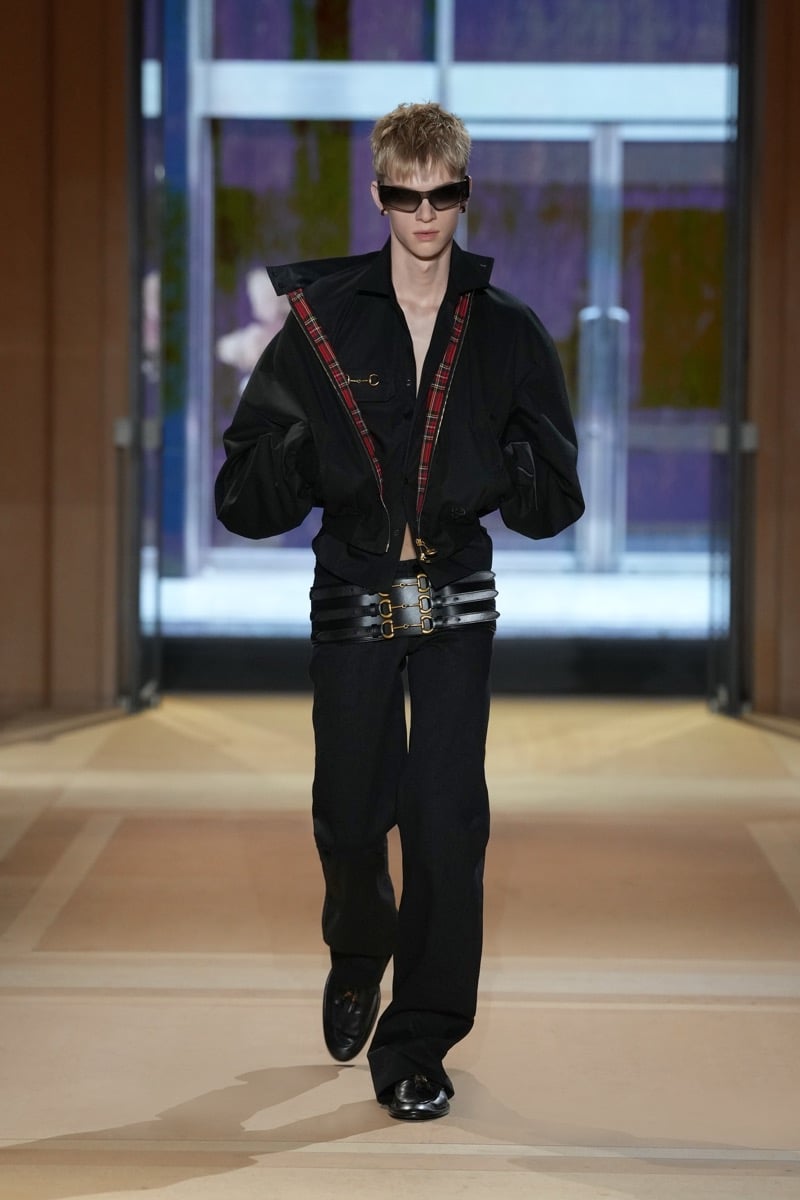 A model in a cropped bomber with tartan trim, a triple Horsebit belt, and wide trousers, for Gucci's spring-summer 2027 collection