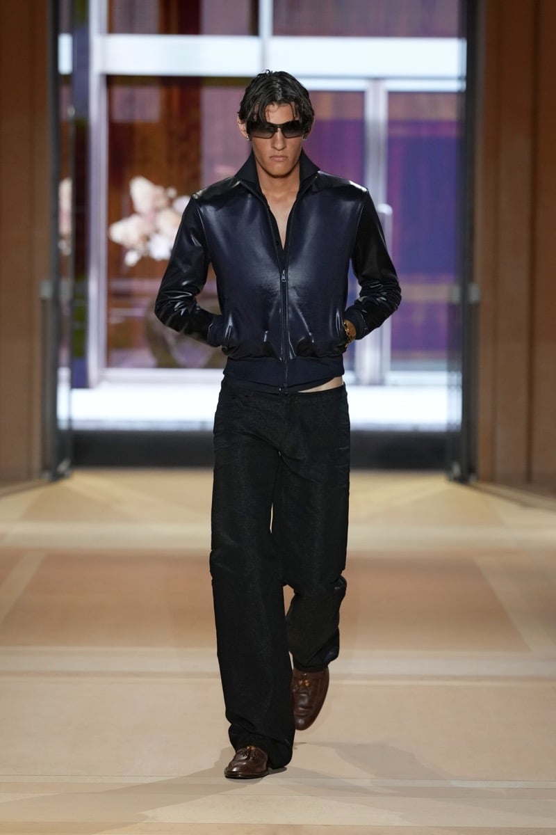 A model in a glossy zip jacket with wide-leg jeans and tassel loafers, for Gucci's spring-summer 2027 collection