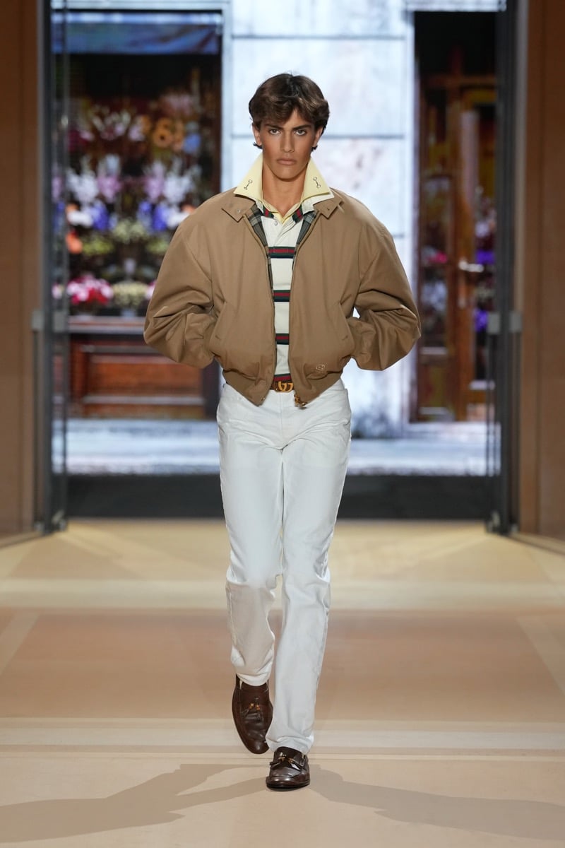 A model in a Harrington jacket over a striped rugby polo, with jeans and tassel loafers, for Gucci's spring-summer 2027 collection