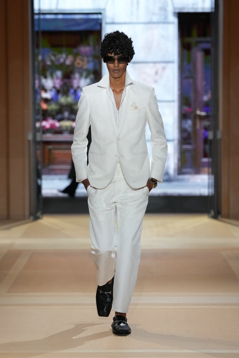 A model in sunglasses and a light-toned suit with a pocket square, with Horsebit loafers, for Gucci's spring-summer 2027 collection