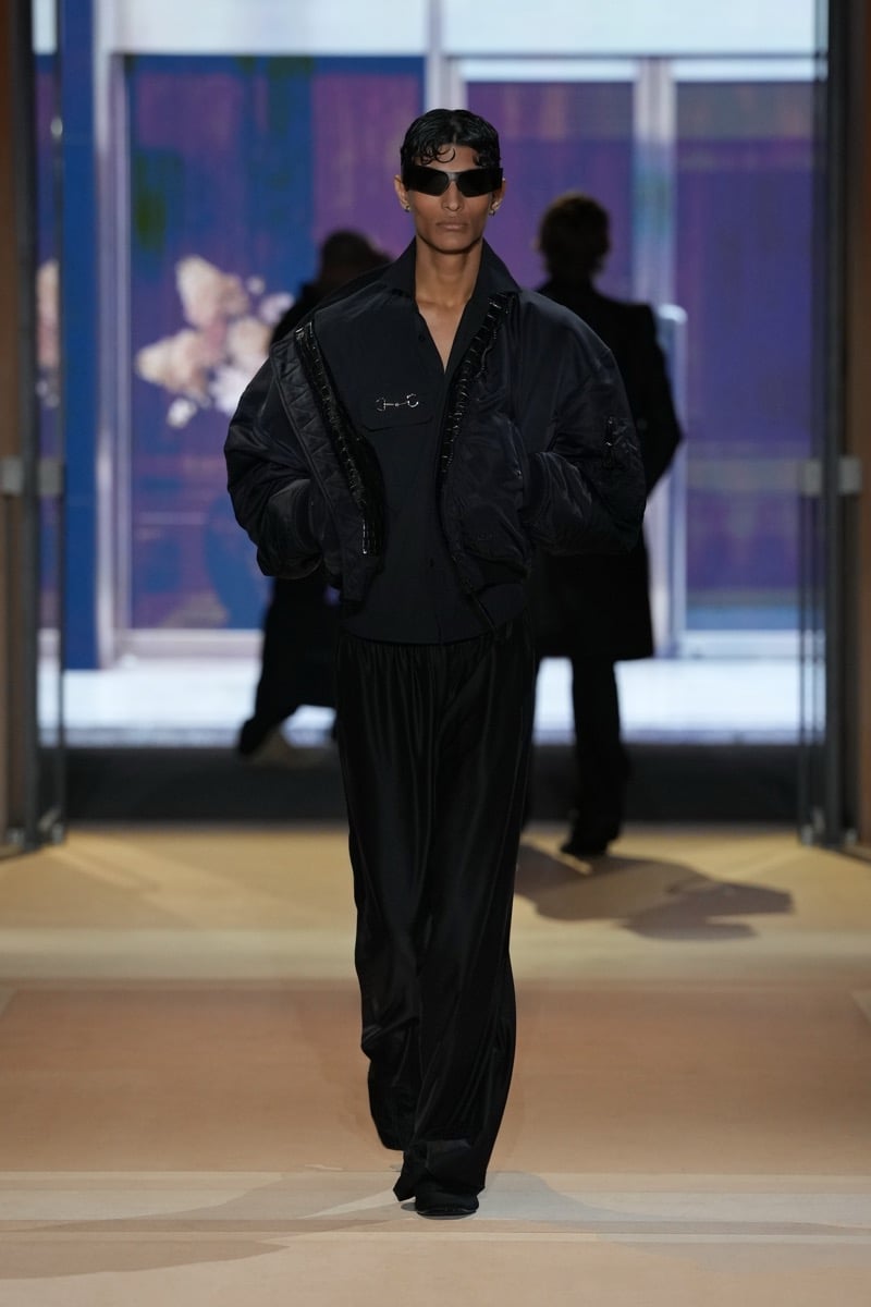 A model in a quilted bomber over a Horsebit-detail shirt, with fluid wide trousers, for Gucci's spring-summer 2027 collection