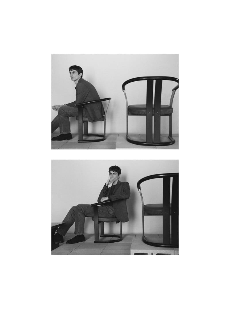 Two black-and-white frames of Henry Kitcher seated in a curved-arm chair in a blazer and jeans, one in profile and one with a hand at his chin, for Massimo Dutti's The Loft
