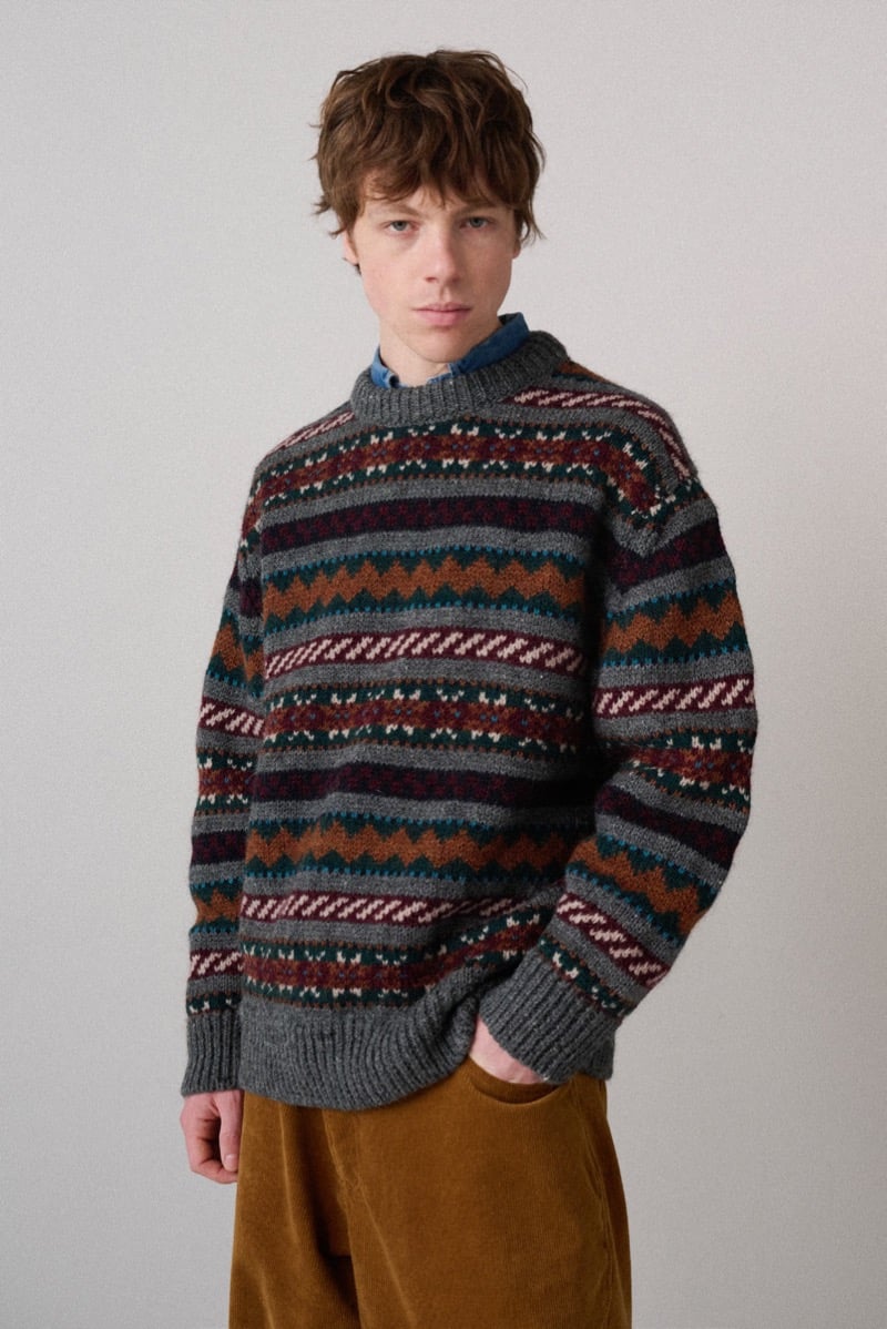A model in a gray sweater with a multicolor striped Fair Isle pattern, for Howlin's fall-winter 2026 collection