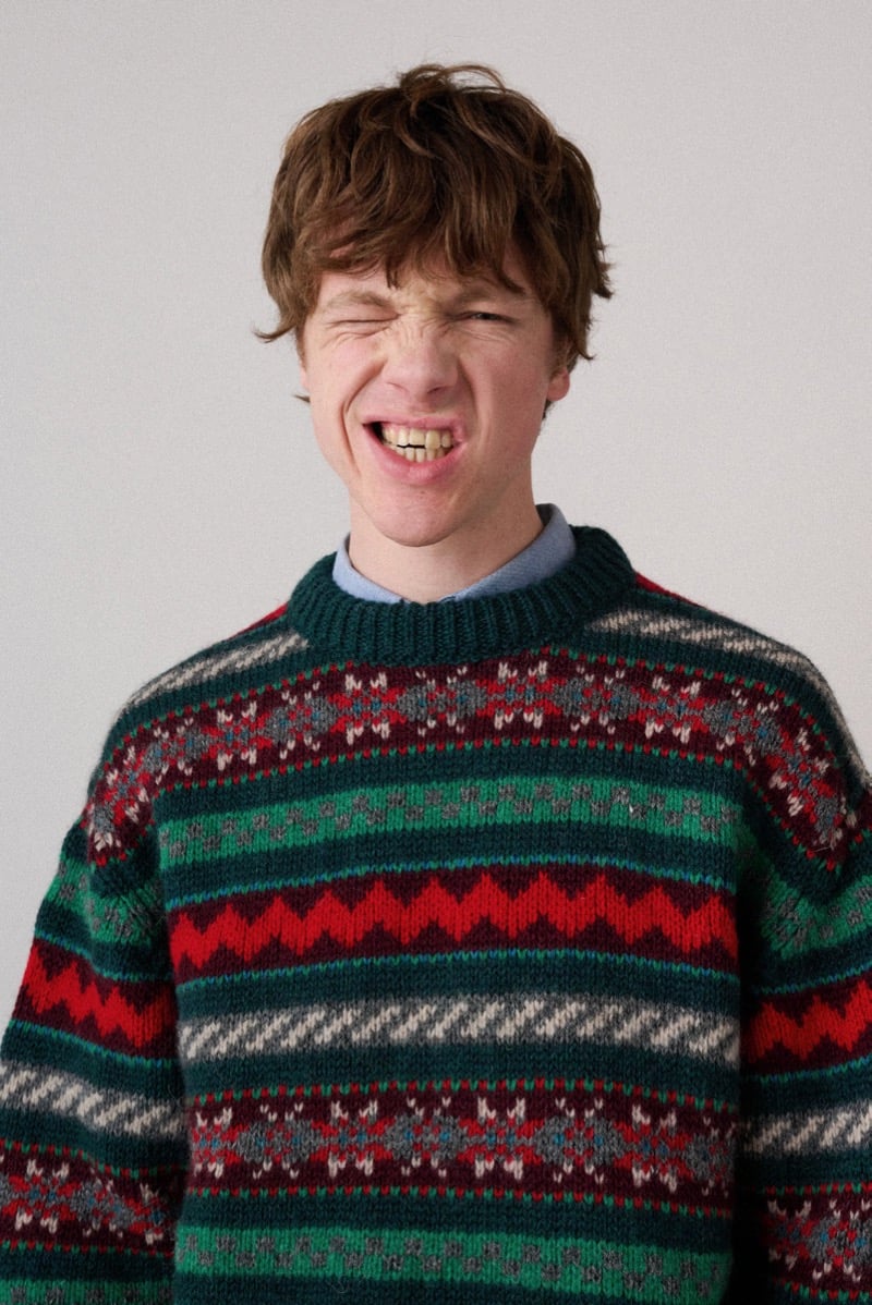 A model in a green and red Fair Isle sweater with a zigzag pattern, for Howlin's fall-winter 2026 collection