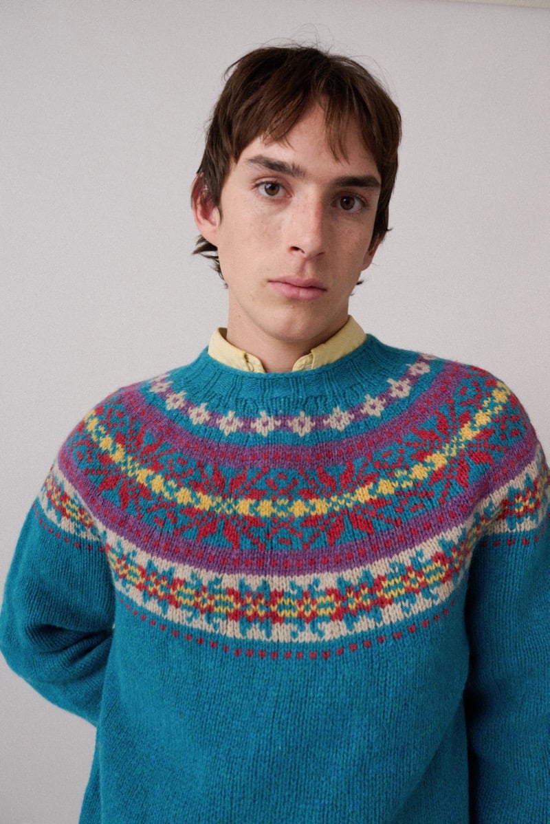 A model in a teal sweater with a colorful patterned yoke, for Howlin's fall-winter 2026 collection