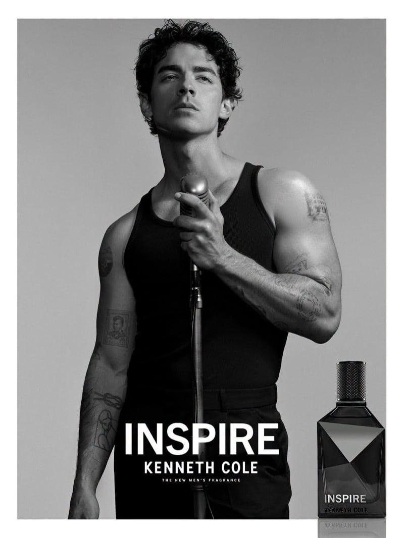 Joe Jonas holds a vintage microphone stand in a tank top beside a bottle of Kenneth Cole INSPIRE in the fragrance's campaign ad.