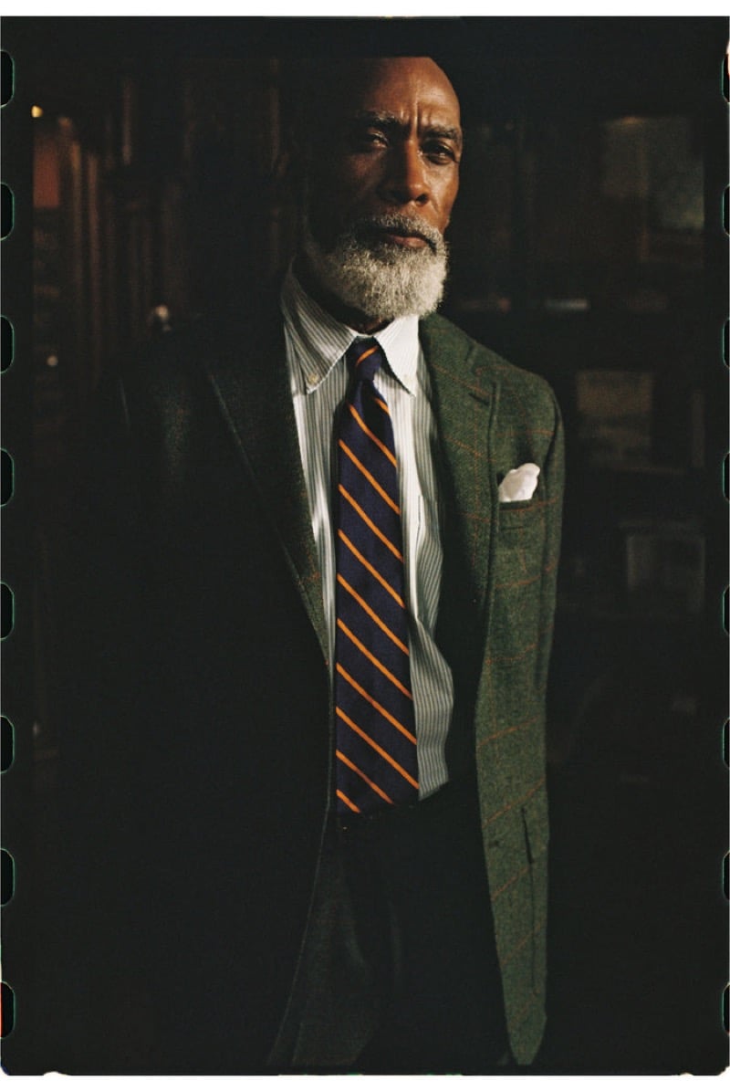 An older model with a gray beard wears a green windowpane tweed sport coat over a striped shirt with a striped tie and a pocket square, for J. Press fall-winter 2026