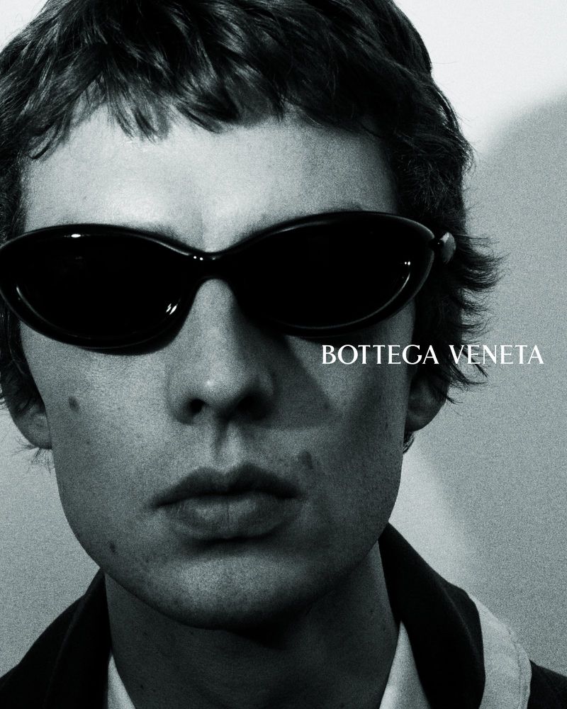 Close-up of Leon Dame in glossy wraparound Bottega Veneta sunglasses