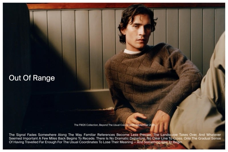 Liam Kelly reclining against a paneled wall in a basketweave-knit wool sweater for Massimo Dutti's Out of Range edit