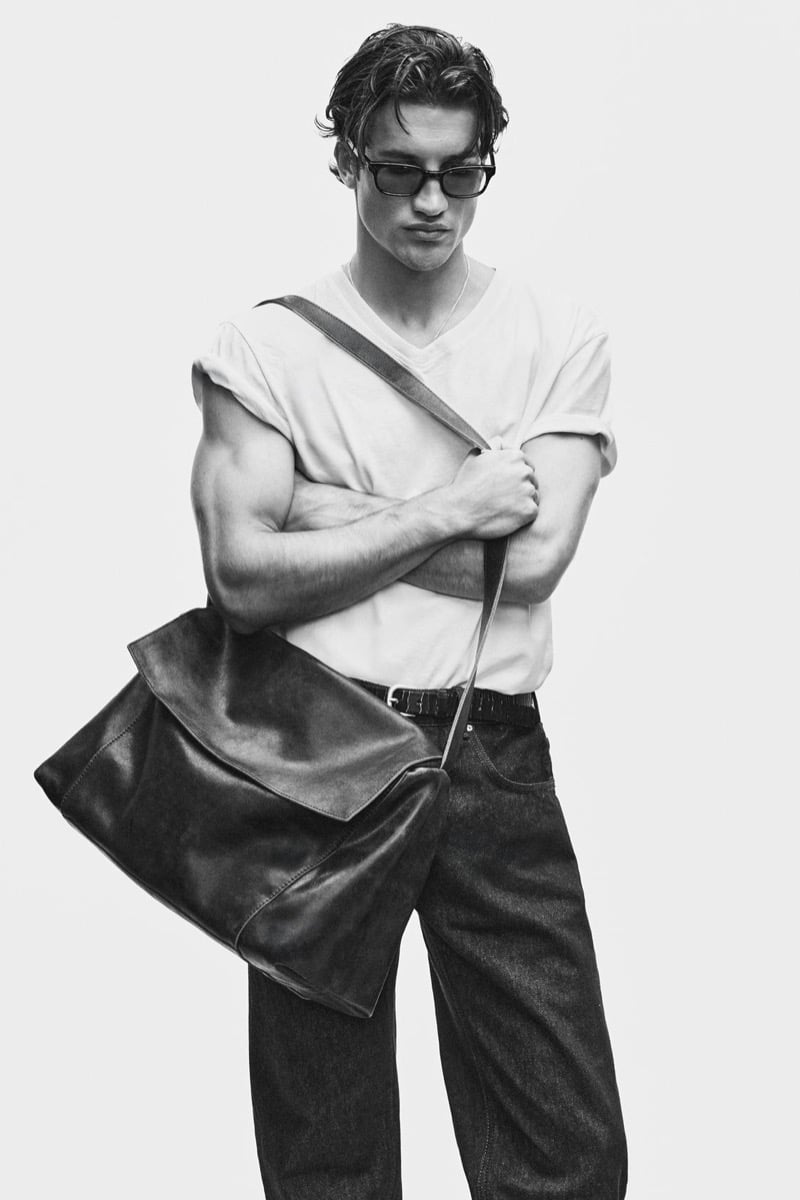 Max Knott in sunglasses with a white v-neck tee and leather shoulder bag for Zara's 90's Archive