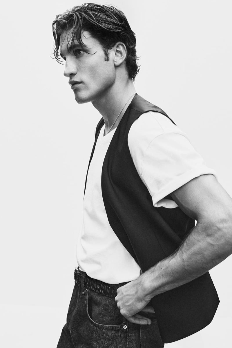 Max Knott in profile wearing a dark waistcoat over a white tee and jeans for Zara's 90's Archive