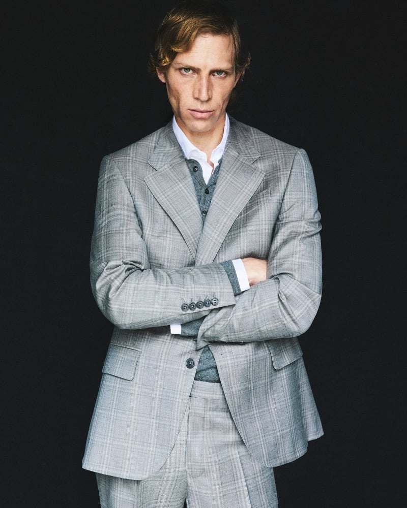 Mike Vasilakis wears a gray checked suit with his arms crossed for Pal Zileri's fall-winter 2026 campaign.