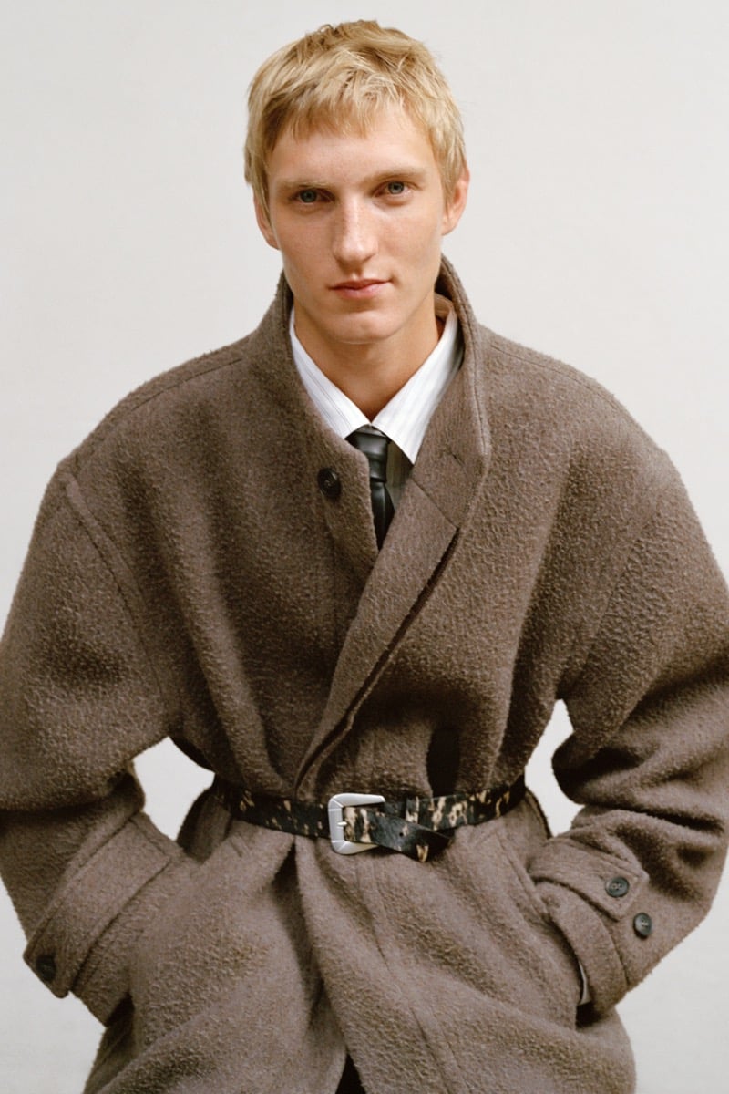 Pierrick Grégoire in a textured wool coat cinched with an animal-print belt over a striped shirt and tie