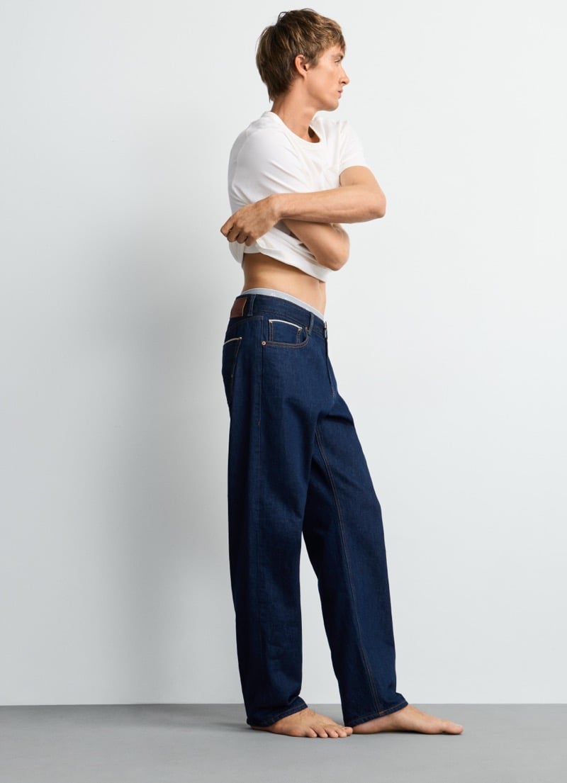 Samuel Curtis in profile, tee lifted to show the waistband of Pepe Jeans' straight-leg Dalston selvedge jean