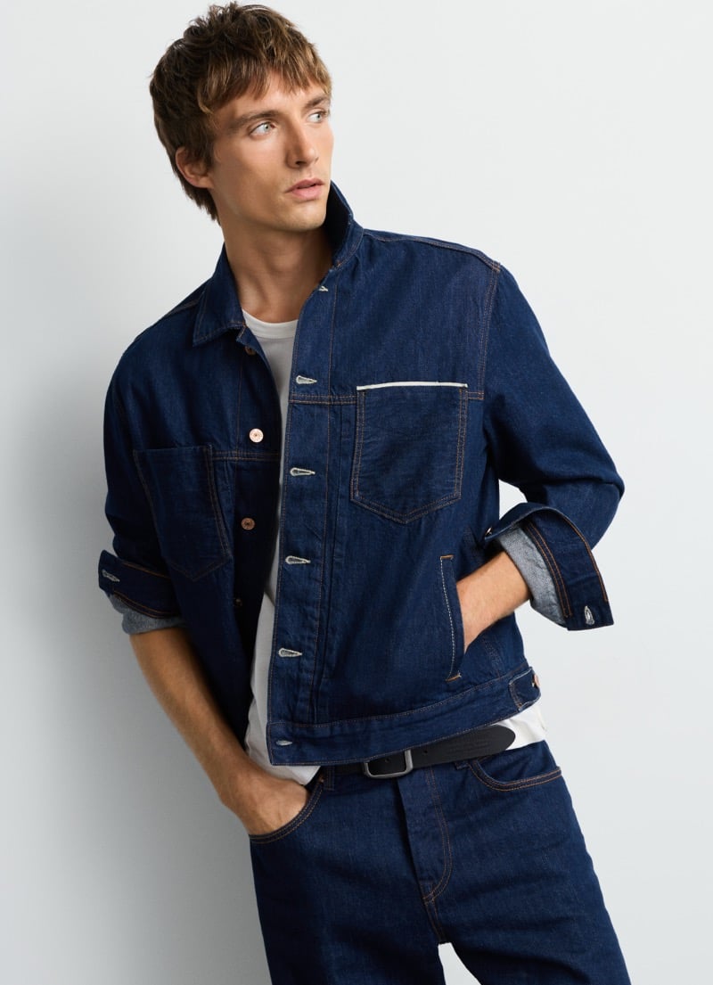 Samuel Curtis looks off to the side in Pepe Jeans' rigid selvedge trucker jacket, hand in pocket, for the Italian Selvedge capsule