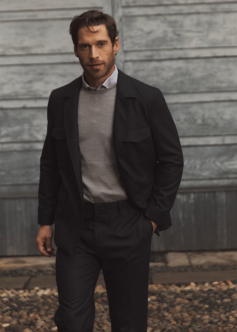 Simone Bredariol in a dark overshirt layered over a gray sweater and striped shirt with dark trousers, for Boglioli's fall-winter 2026 campaign