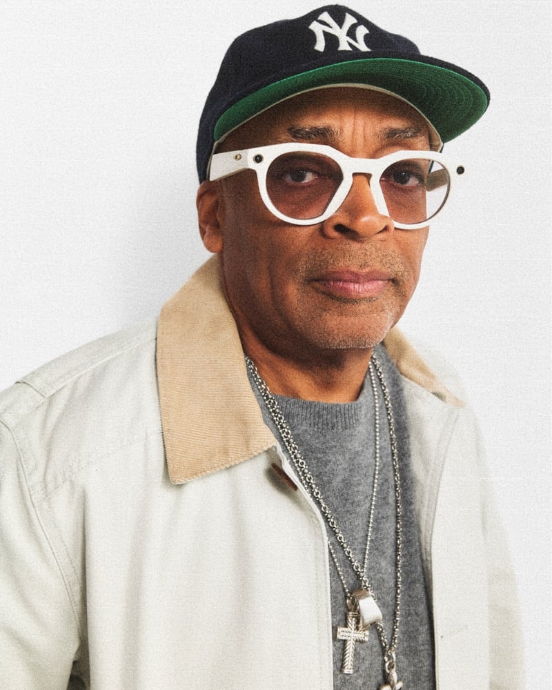 Spike Lee in a Yankees cap, tinted glasses, and a J.Crew Barn Jacket with a corduroy collar over a gray sweater